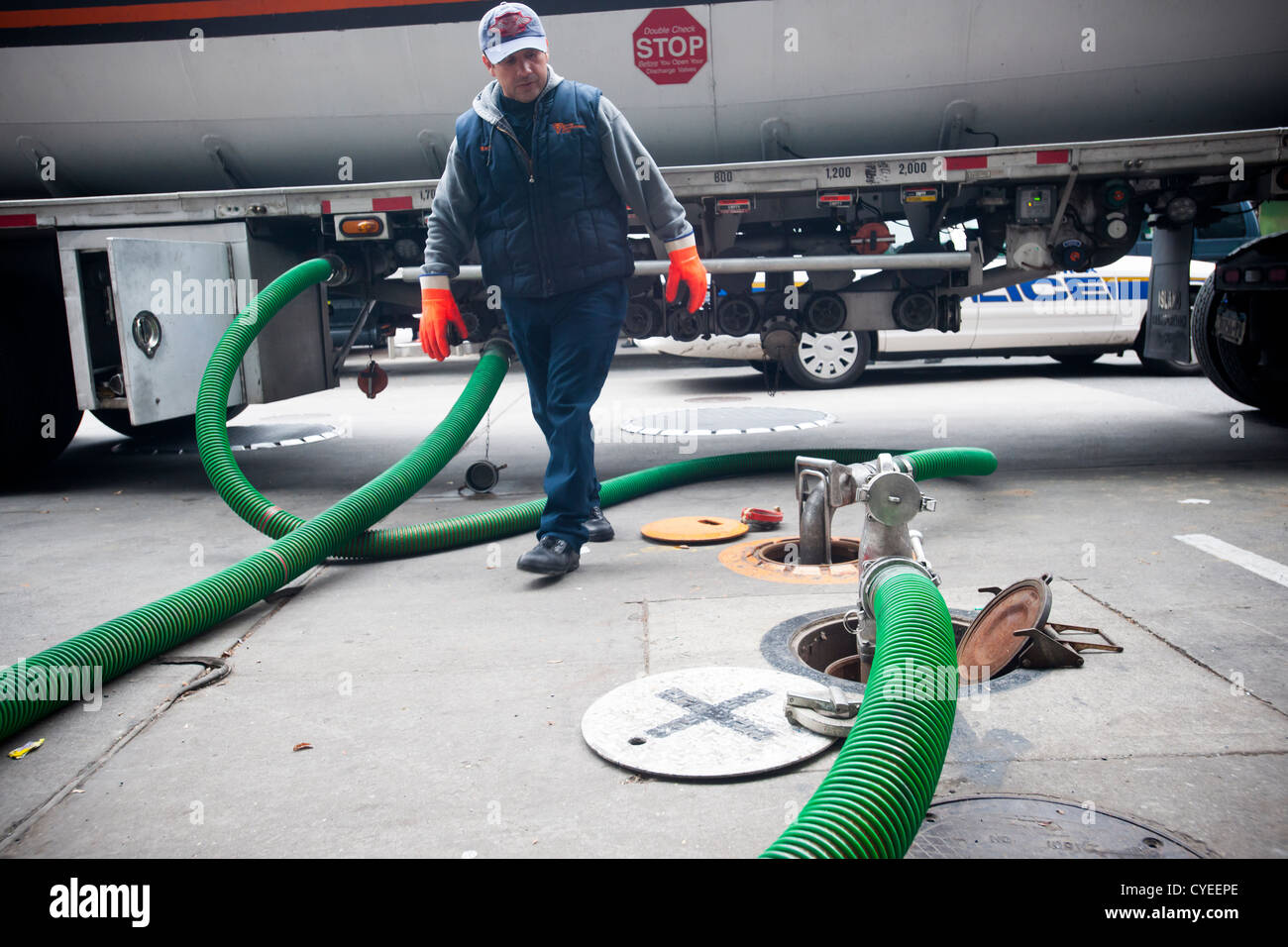Ein Kraftstoff-LKW-Betreiber liefert Benzin an einer Tankstelle Hess in der Clinton-Viertel von Manhattan in New York City Stockfoto