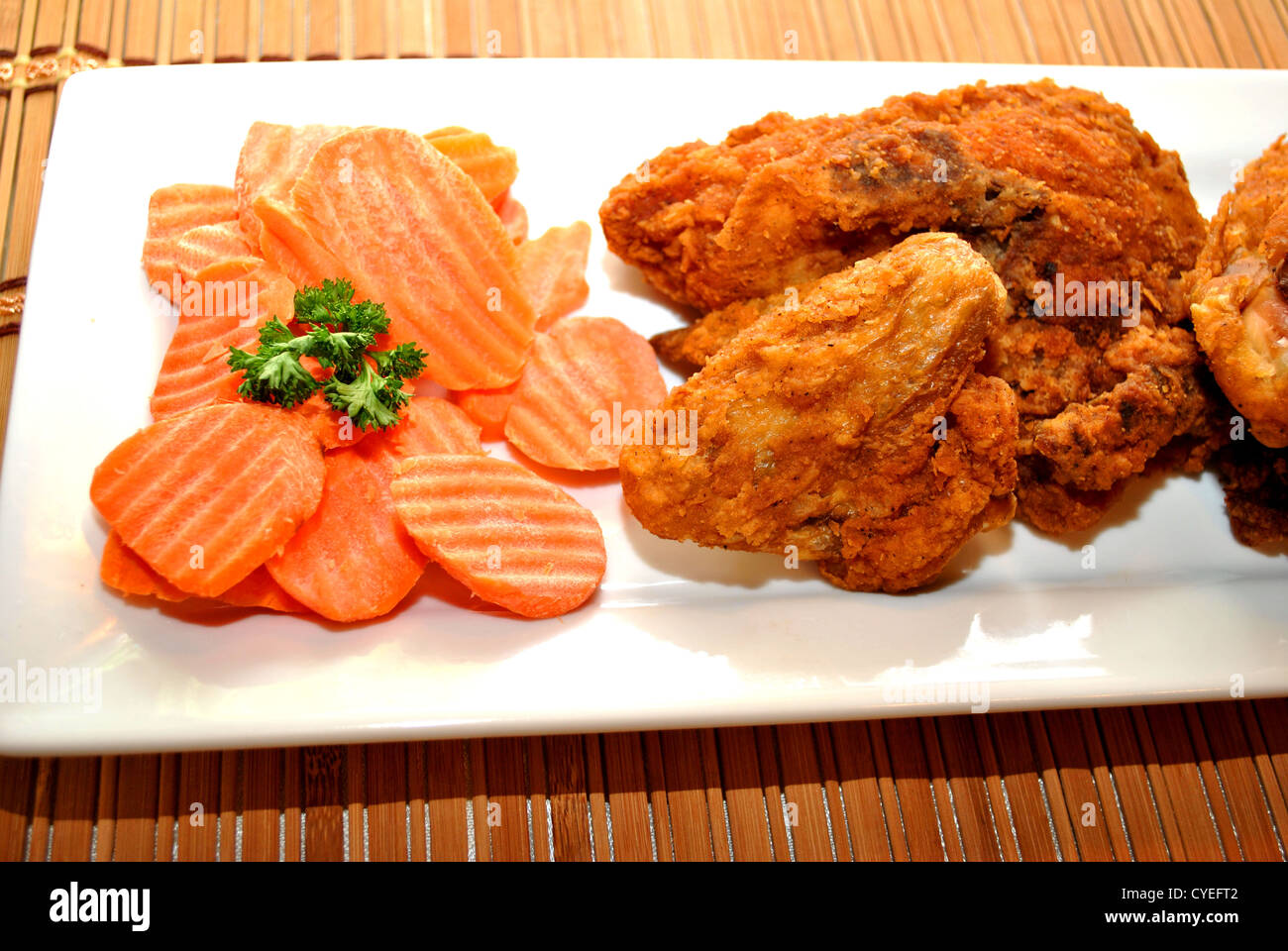 Teller mit gebratenem Huhn und frische Karotten in Scheiben geschnitten Stockfoto