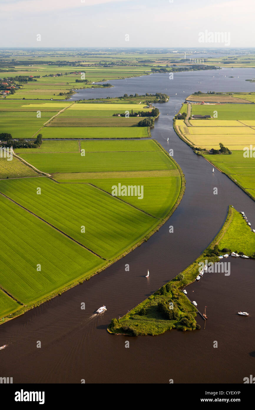 Die Niederlande, in der Nähe von Uitwellingerga-Antenne. Ackerland und Boote verankert auf der kleinen Insel. Stockfoto