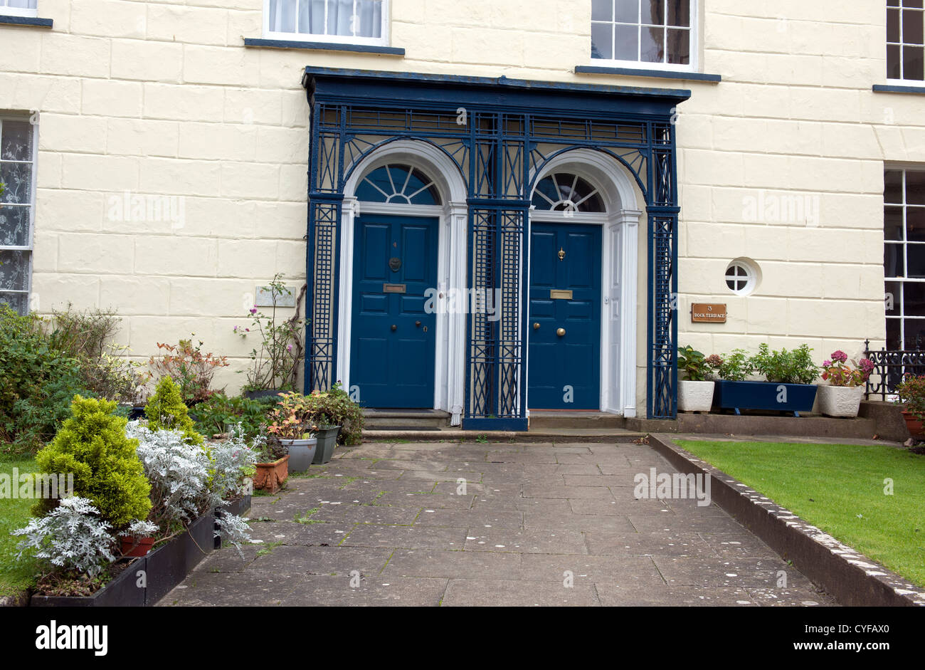 Zwei blau lackierte Türen mit reich verzierten Vorhalle, Tenby, Pembrokeshire, Wales. Stockfoto