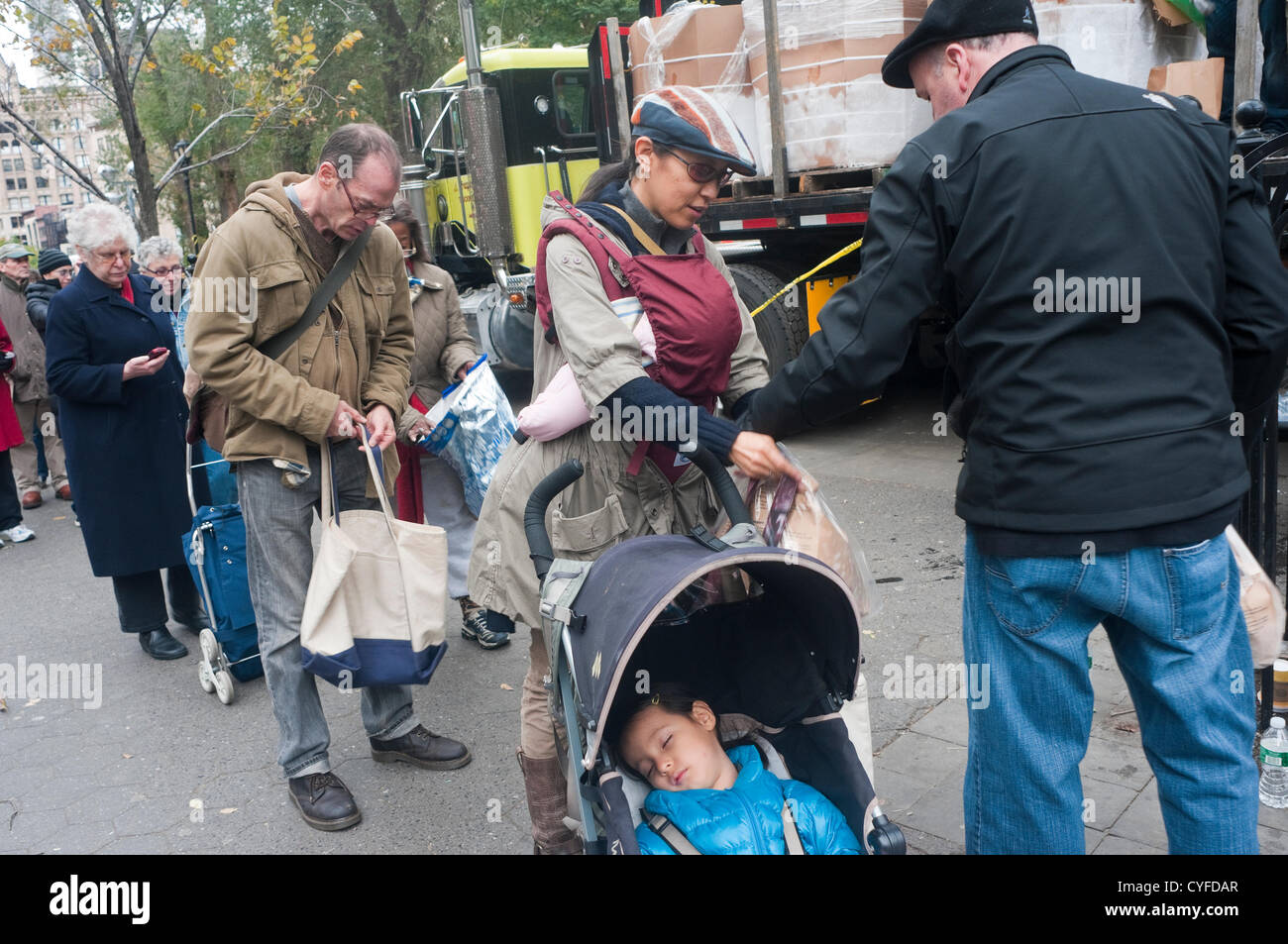 New York, NY - 2. November 2012 die Bewohner von Manhattan, die ohne Strom, Wärme, Heißwasser, Telefon, Nahverkehr, und in einigen Fällen fließendem Wasser, in Union Square Line kostenlos Trockeneis in der Nachmahd des Hurrikans ein Sandstrand. Stockfoto