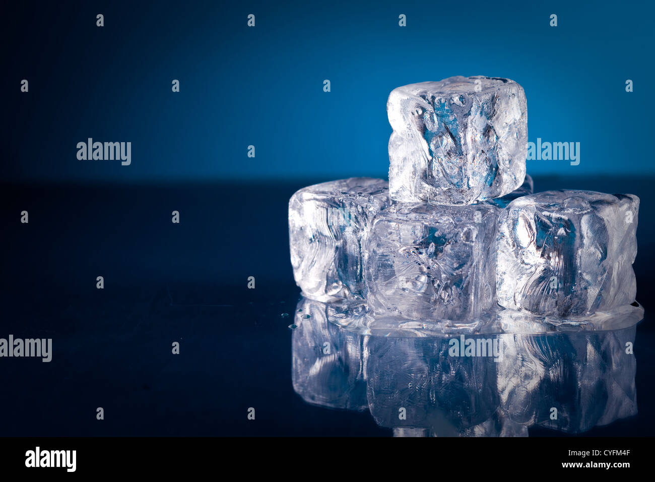 Gefrorenen Eiswürfel auf blauem Hintergrund mit Reflexion Stockfoto