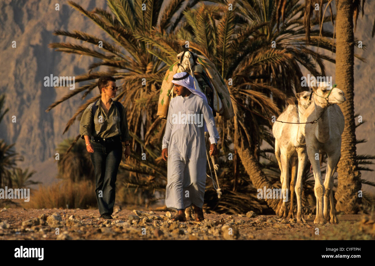 Ägypten, Dahab, Rotes Meer, Sinai, Beduinen mit seinen Kamelen und Frau, Touristen. Stockfoto