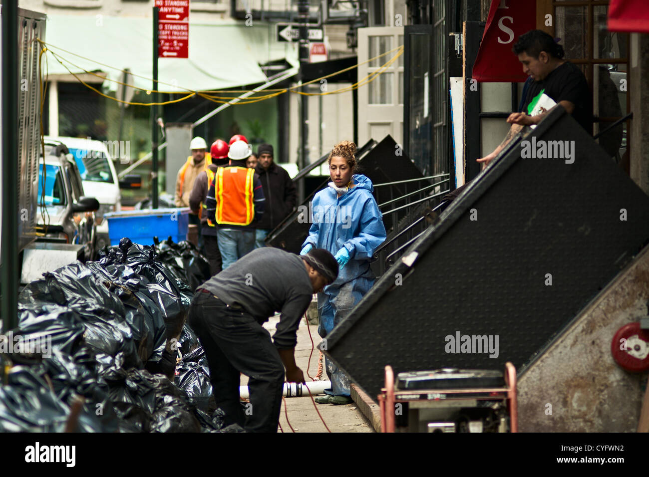 3. November 2012, New York, NY, USA.  Menschen an der Pearl Street in lower Manhattan bereinigen Kleinunternehmen fünf Tage nachdem Hurrikan Sandy Teile der Stadt verwüstete. Stockfoto