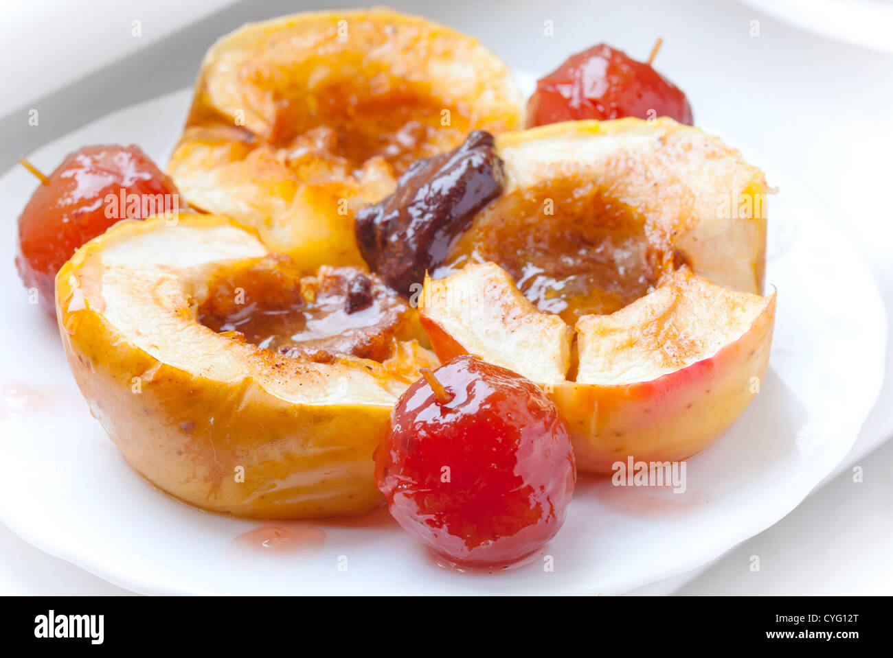Bratäpfel mit Gewürzen, Honig und Schokolade auf weißen Teller Stockfoto
