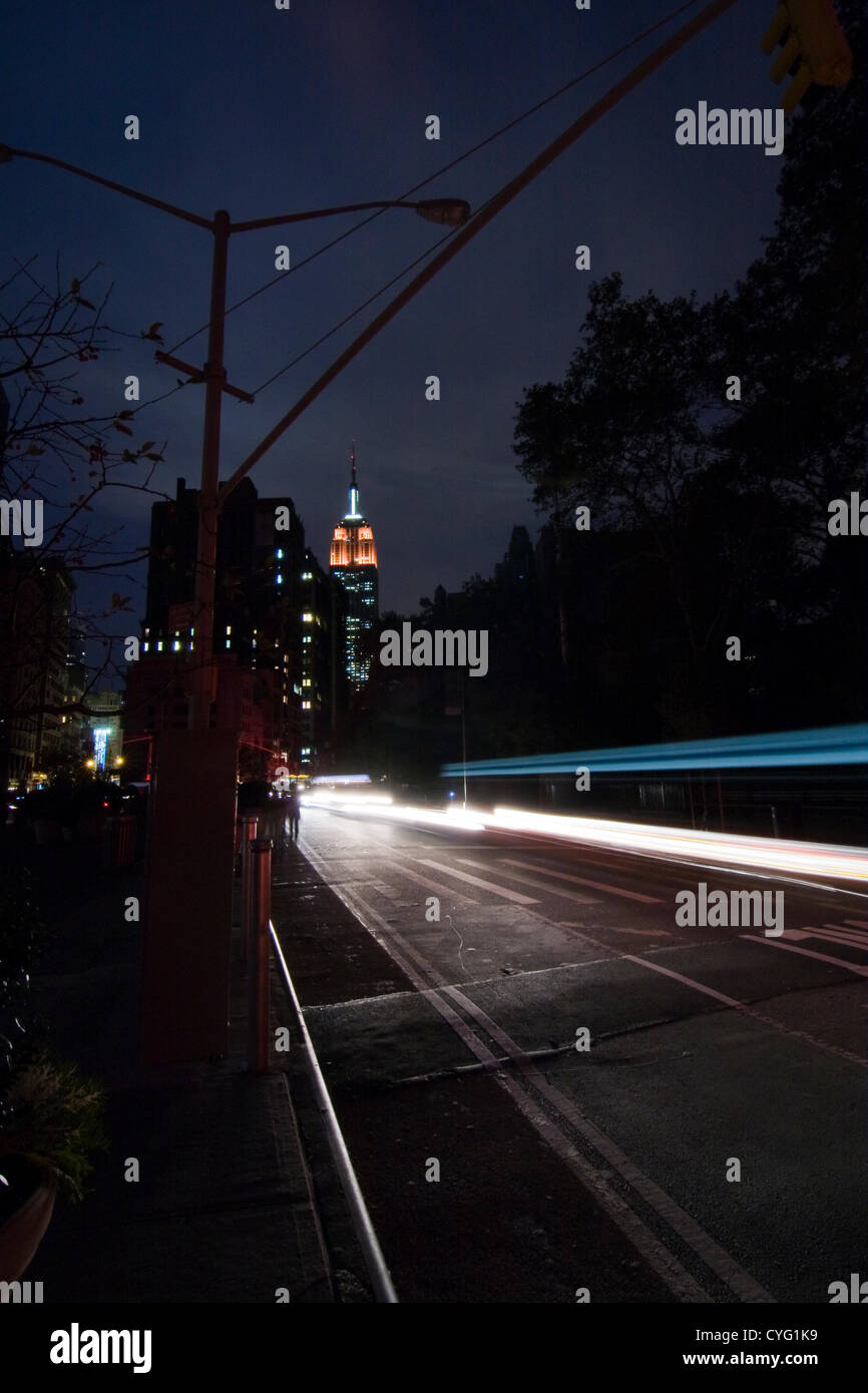 New York USA. 1. November 2012. Blick nach Norden am Broadway in New York City im Stadtteil Chelsea in der Abenddämmerung. Das berühmte Empire State Building mit roten Lichtern wie Autos Reisen Süd in der Dunkelheit. Laternen und Ampeln bleiben dunkel 4 Tage nach Hurrikan Sandy auf Teile der Stadt unter 29th Street sichtbar in der Ferne Stromausfall. Stockfoto