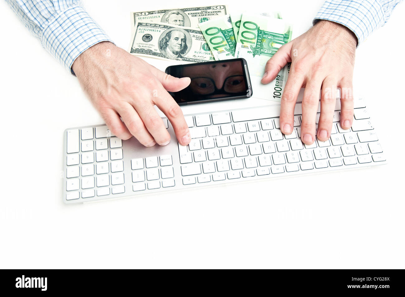Geschäftsmann Tippen auf weiße Tastatur, Smartphone und etwas Geld auf den Tisch. Stockfoto