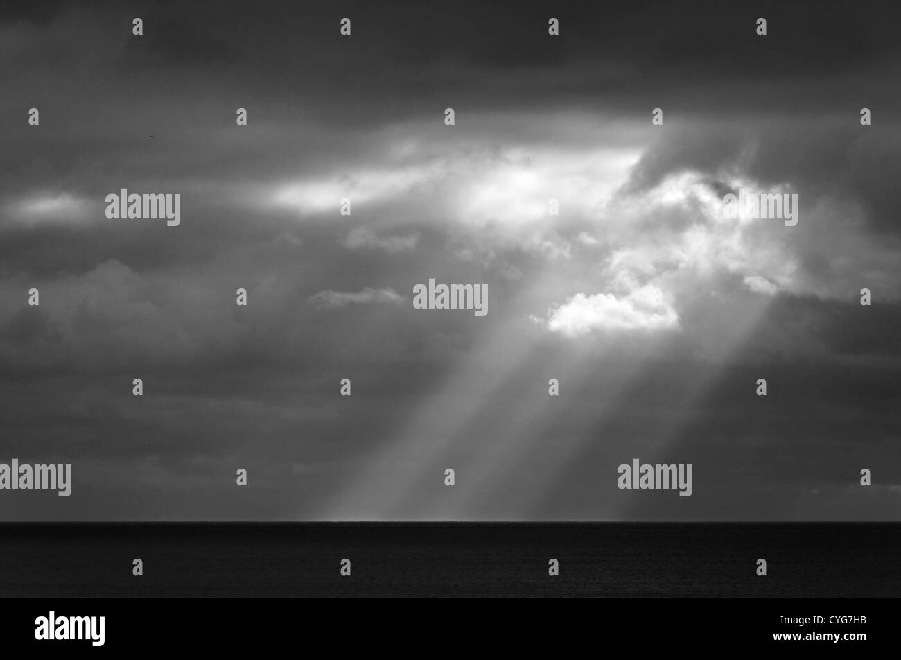 Sonnenstrahl am Meer, stürmisches Wetter, schwarz / weiß Fotografie Stockfoto