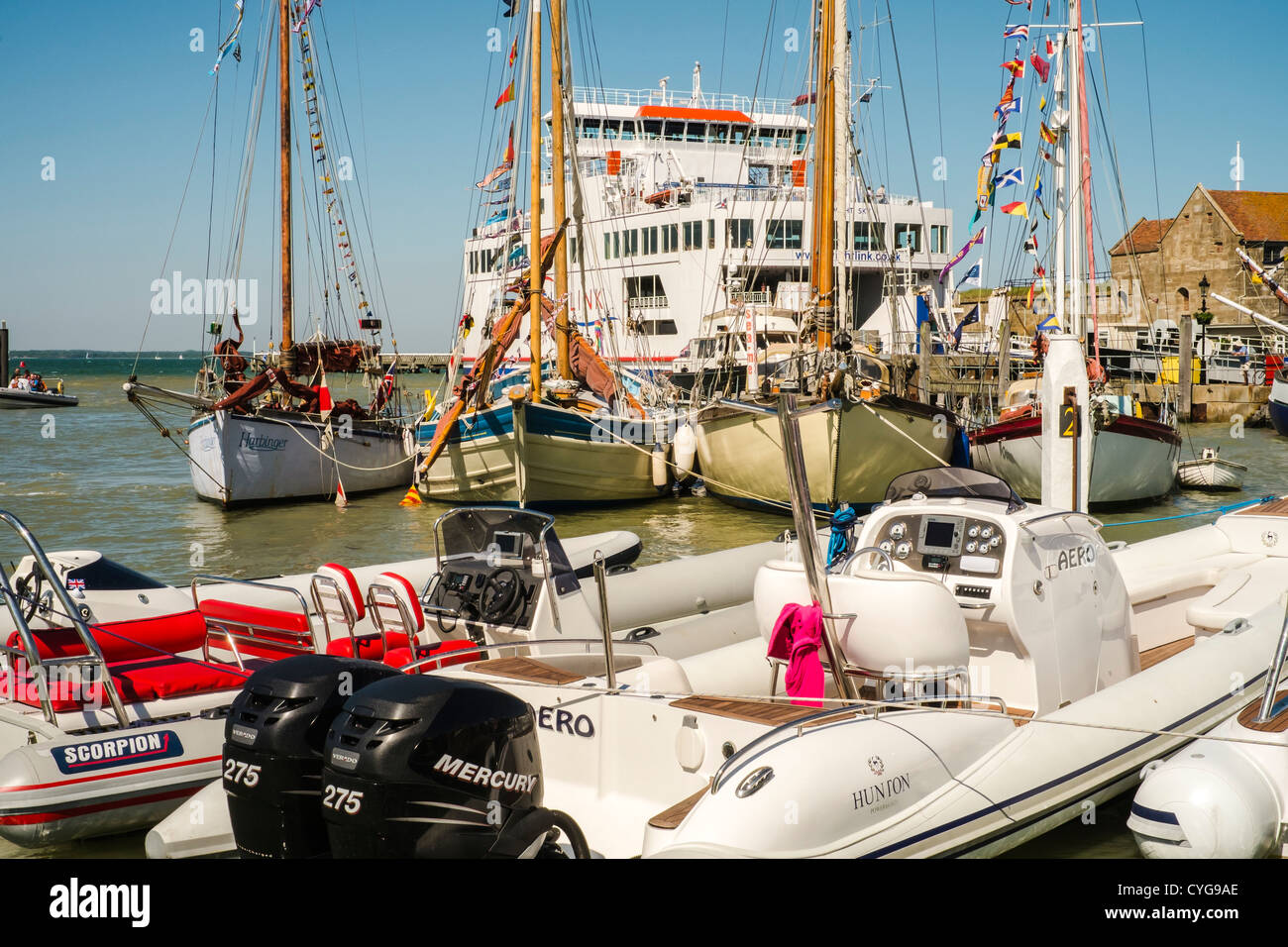 Alte Segelschiffe (Beleuchter) Linie zwischen den modernen Rippen und die Fähre im Hafen von Lymington, Isle Of Wight. Stockfoto