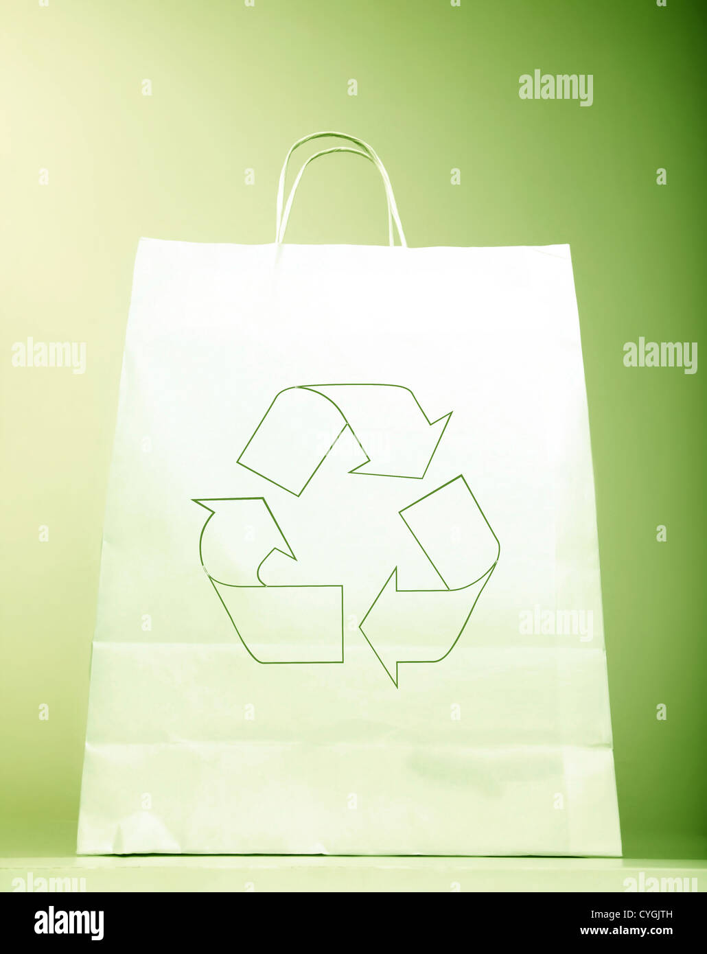 Weiße Papiertüte mit Ökologie-Symbol, mit Recycling-Zeichen isoliert auf grünem Hintergrund, wiederverwertbare Einkaufstasche & Eco-Symbol Stockfoto