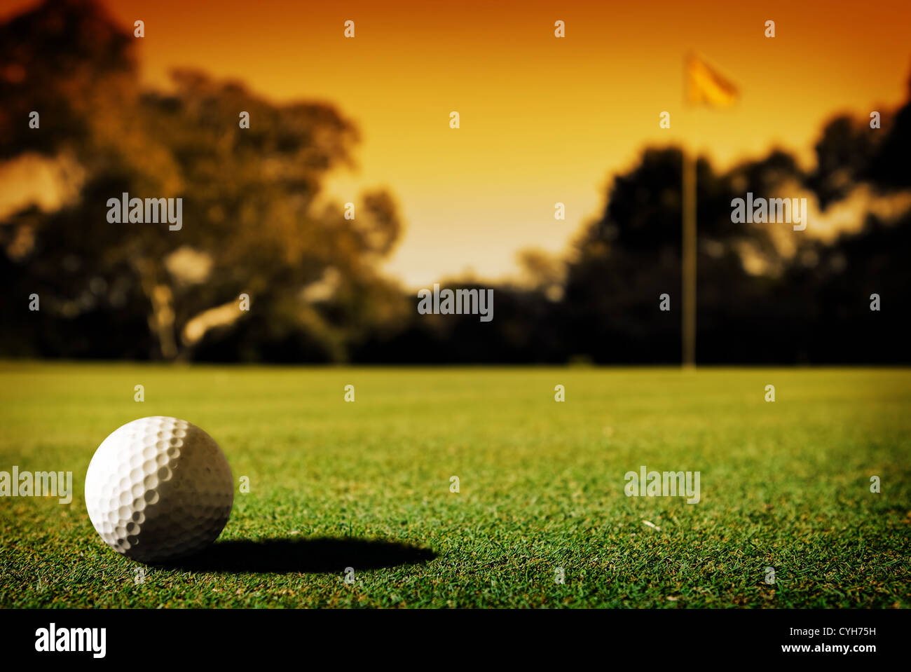 Ein langer Putt auf dem 18. grün wie Sonnenuntergang schließt in Stockfoto