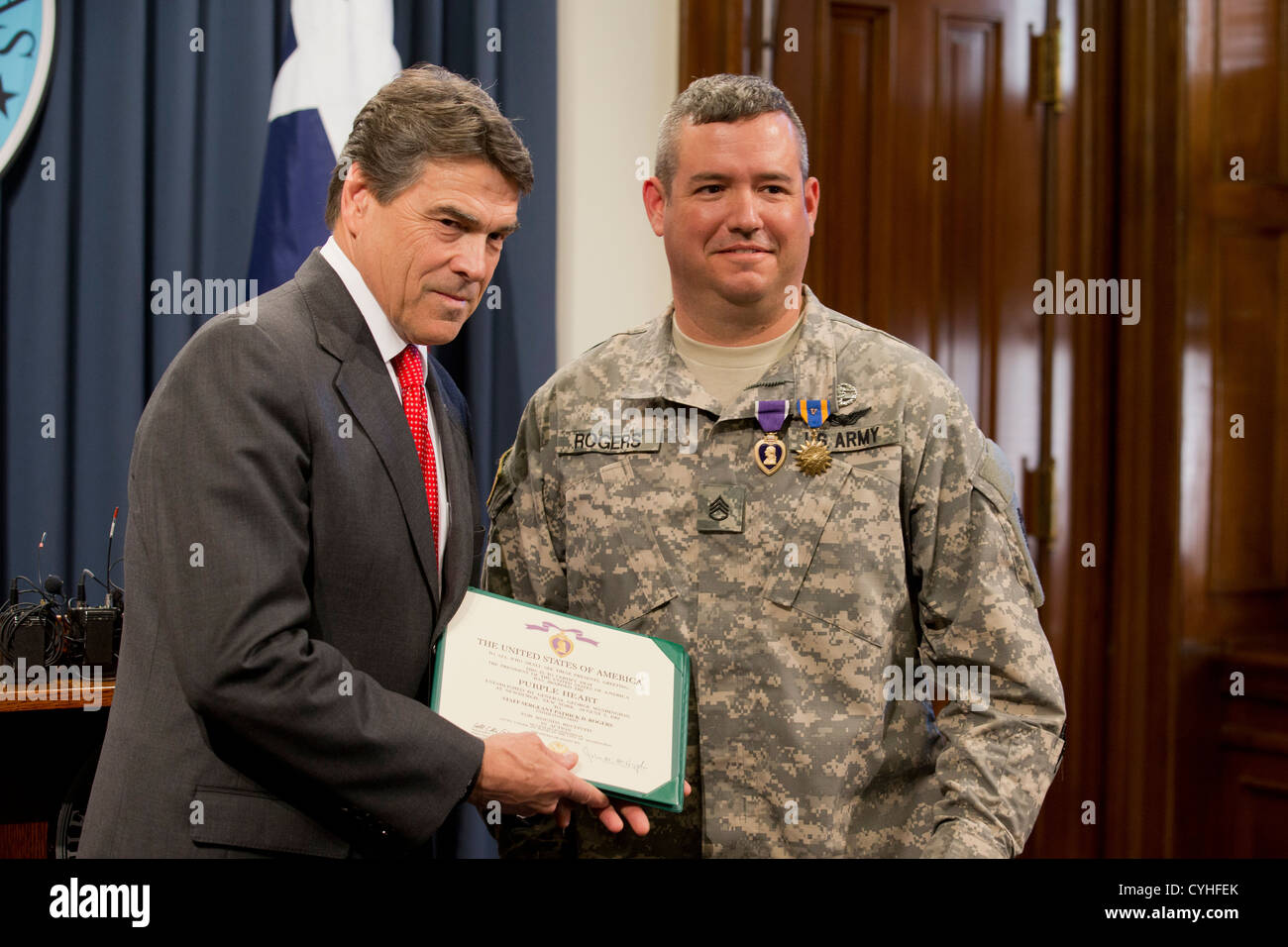Texas-Gouverneur Rick Perry (l) präsentiert das Purple Heart und zwei weiteren Auszeichnungen Armee Flug Medic Stabsunteroffizier Patrick Rogers Stockfoto