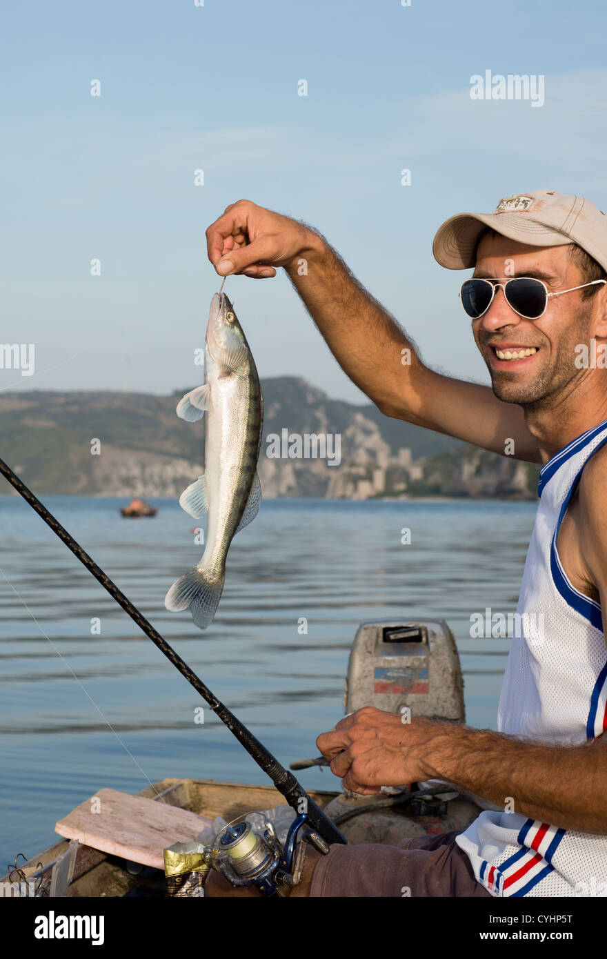 Fischer auf Donau zeigt stolz seinen Fang, ein Sander. Stockfoto