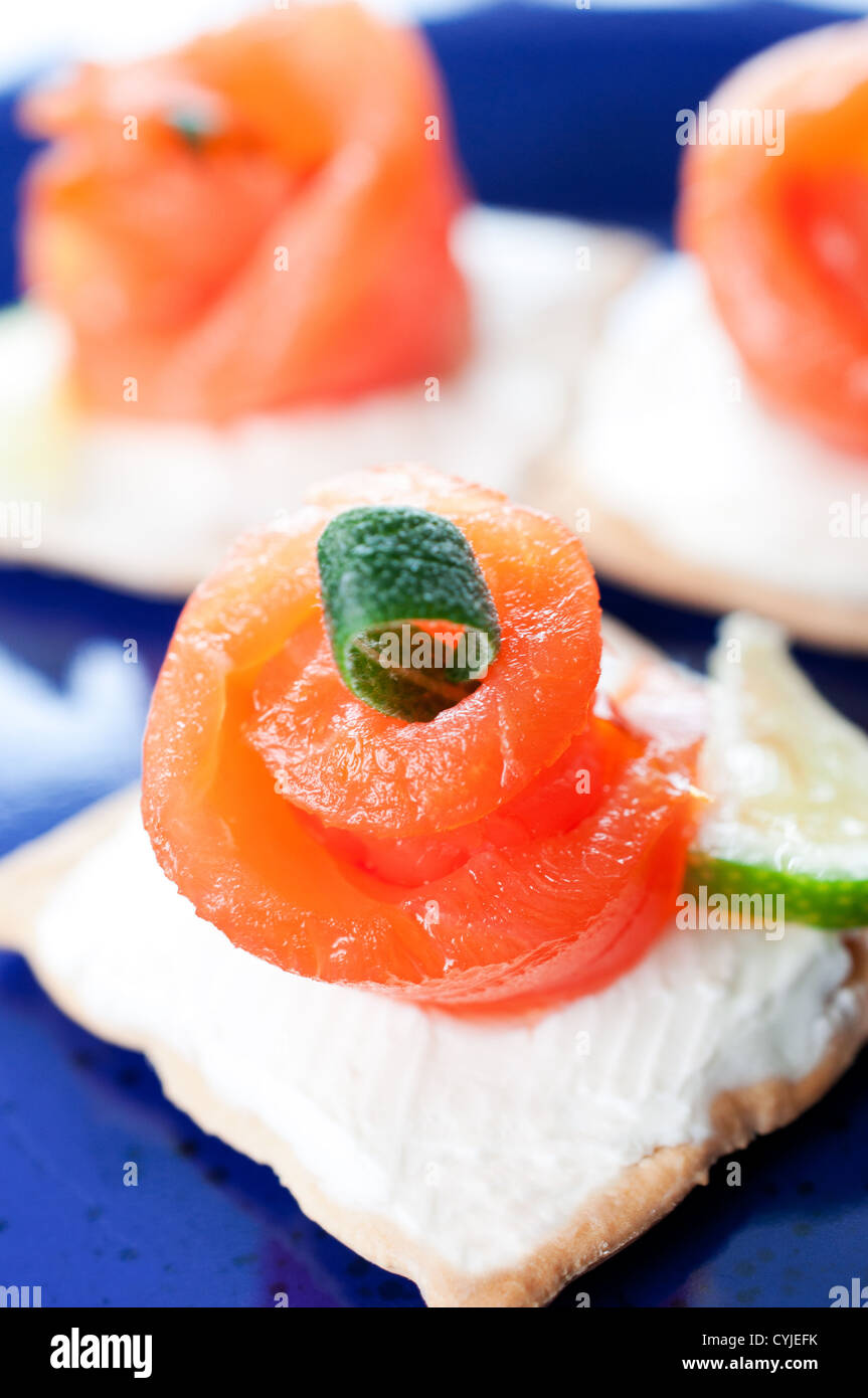 Kanapees mit geräuchertem Lachs und Frischkäse auf blaue Platte Stockfoto