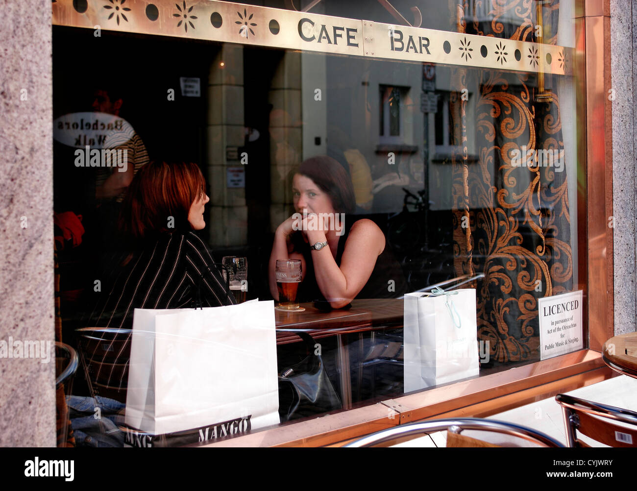 Zwei junge Frauen sitzen am Fenster in einem Pub in Temple