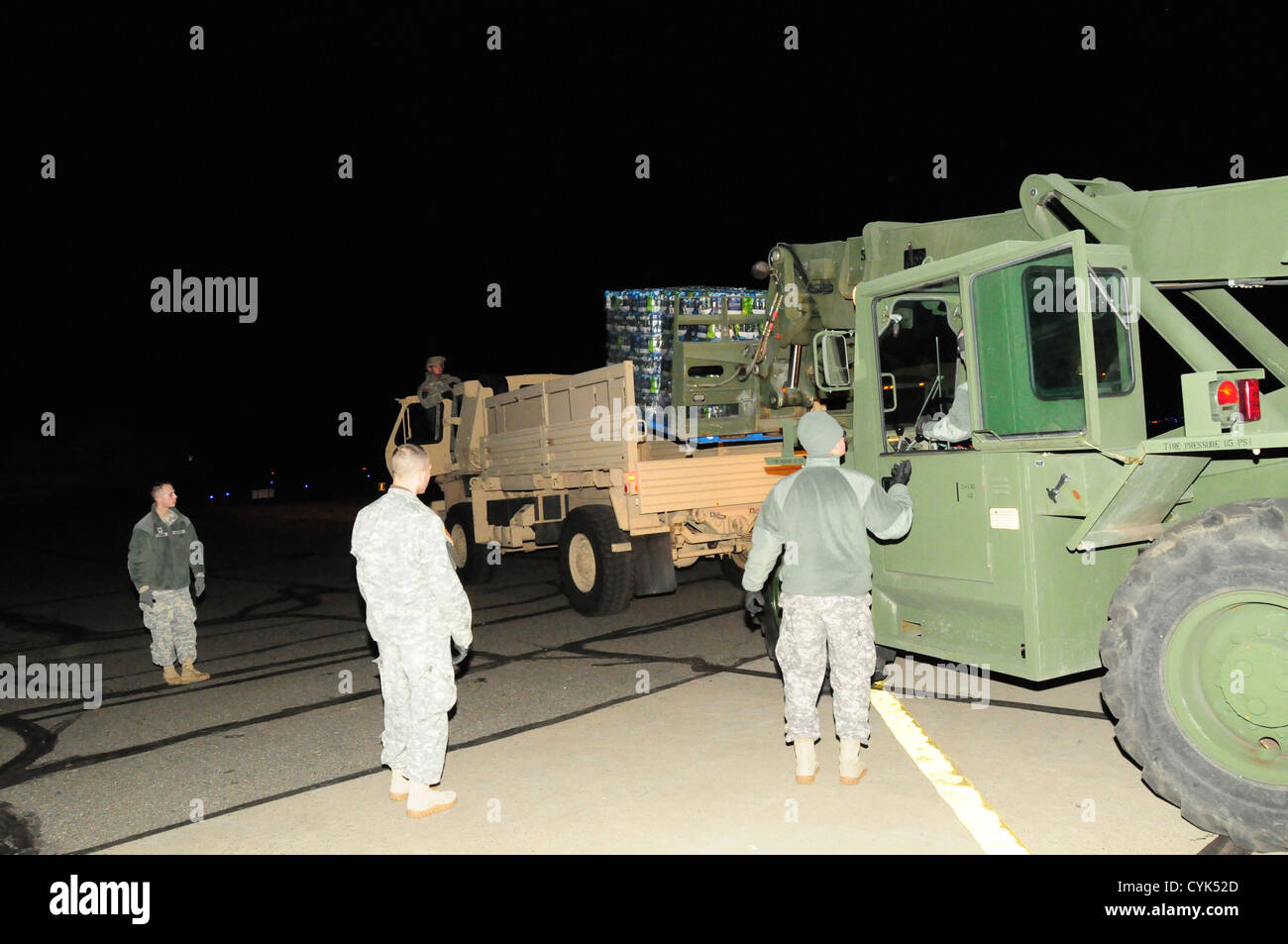 Mitglieder der Armee-Nationalgarde der 102. Und 105. Militärpolizei helfen beim Entladen von 30.000 Flaschen Wasser aus einem C-130-Flugzeug im 107. Luftlift-Flügel für Hurrikan Sandy. Stockfoto