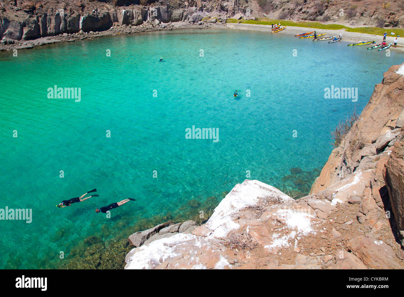 Mexiko, Baja, Sea of Cortez. Schnorcheln in Azure-farbigen Honeymoon Bucht auf Isla Danzante mit Kajaks am Strand. Stockfoto
