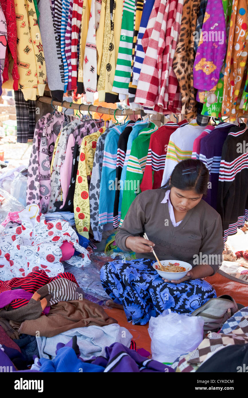 Myanmar, Burma. Kleidung-Lieferanten essen Nudeln mit Stäbchen, "Five-Day"-Markt, Inle-See, Shan-Staat. Stockfoto