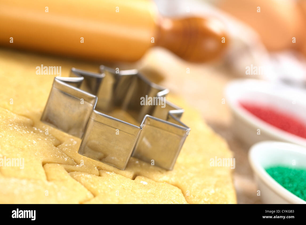 Weihnachtsplätzchen Backen: Ausstecher auf Zucker oder Butter Cookie-Teig mit Nudelholz hinten ausgerollt Stockfoto