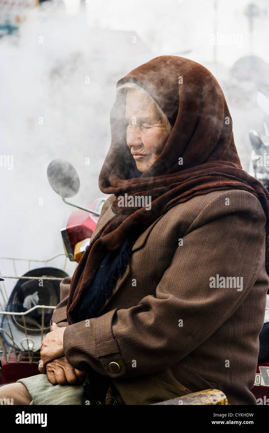 Alten uigurischen Frau schlafend auf dem Markt in Kashgar, Xinjiang, China Stockfoto