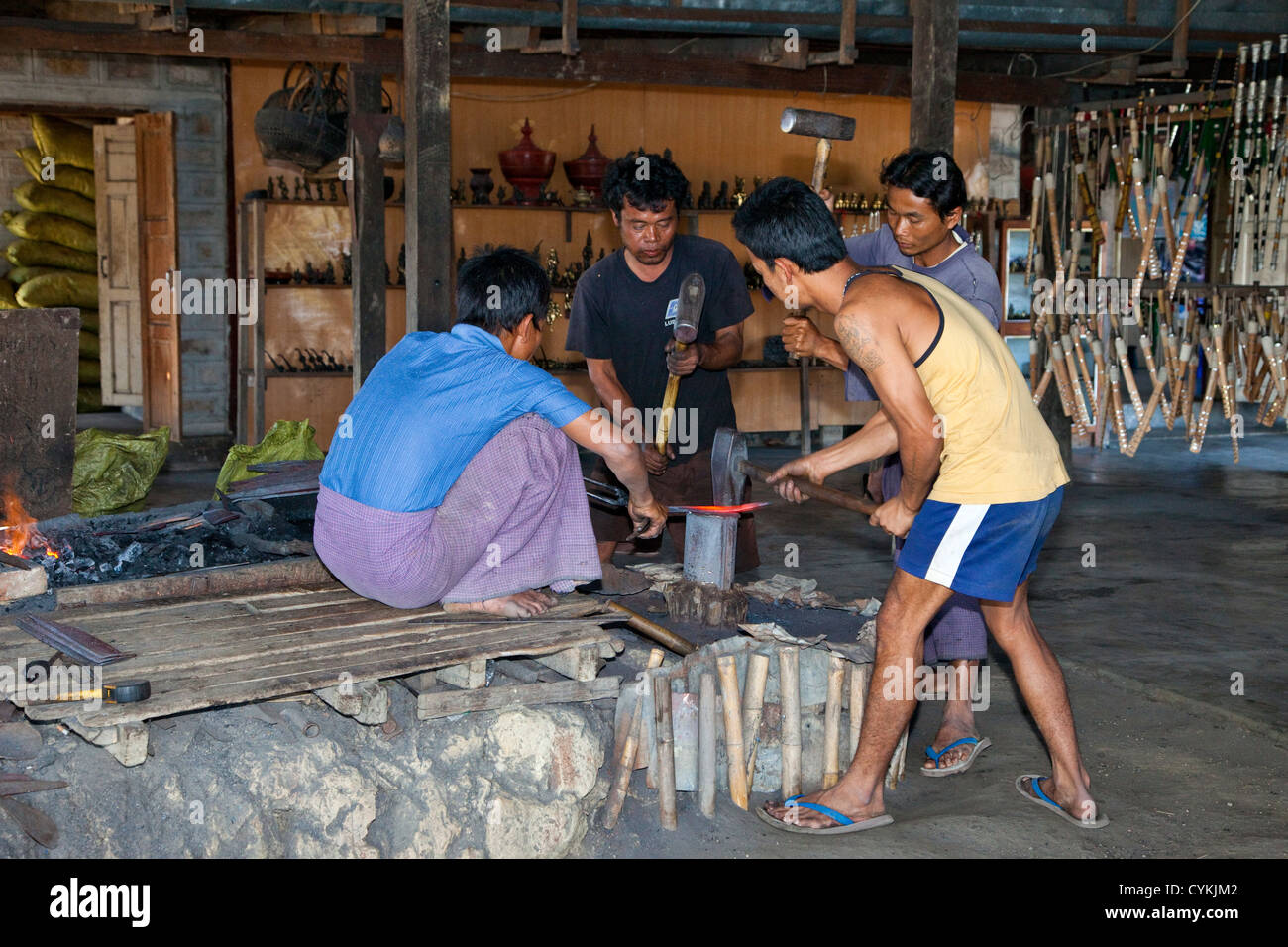Myanmar, Burma. Drei junge Männer Hammer glühendes Metall gerade aus dem Schmied Feuer, Inle-See, Shan-Staat übernommen. Stockfoto