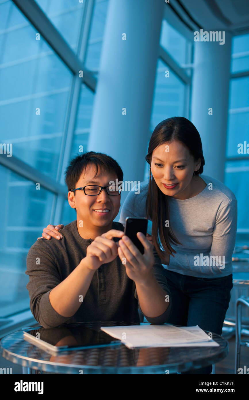 Asian paar Blick auf Handy Stockfoto