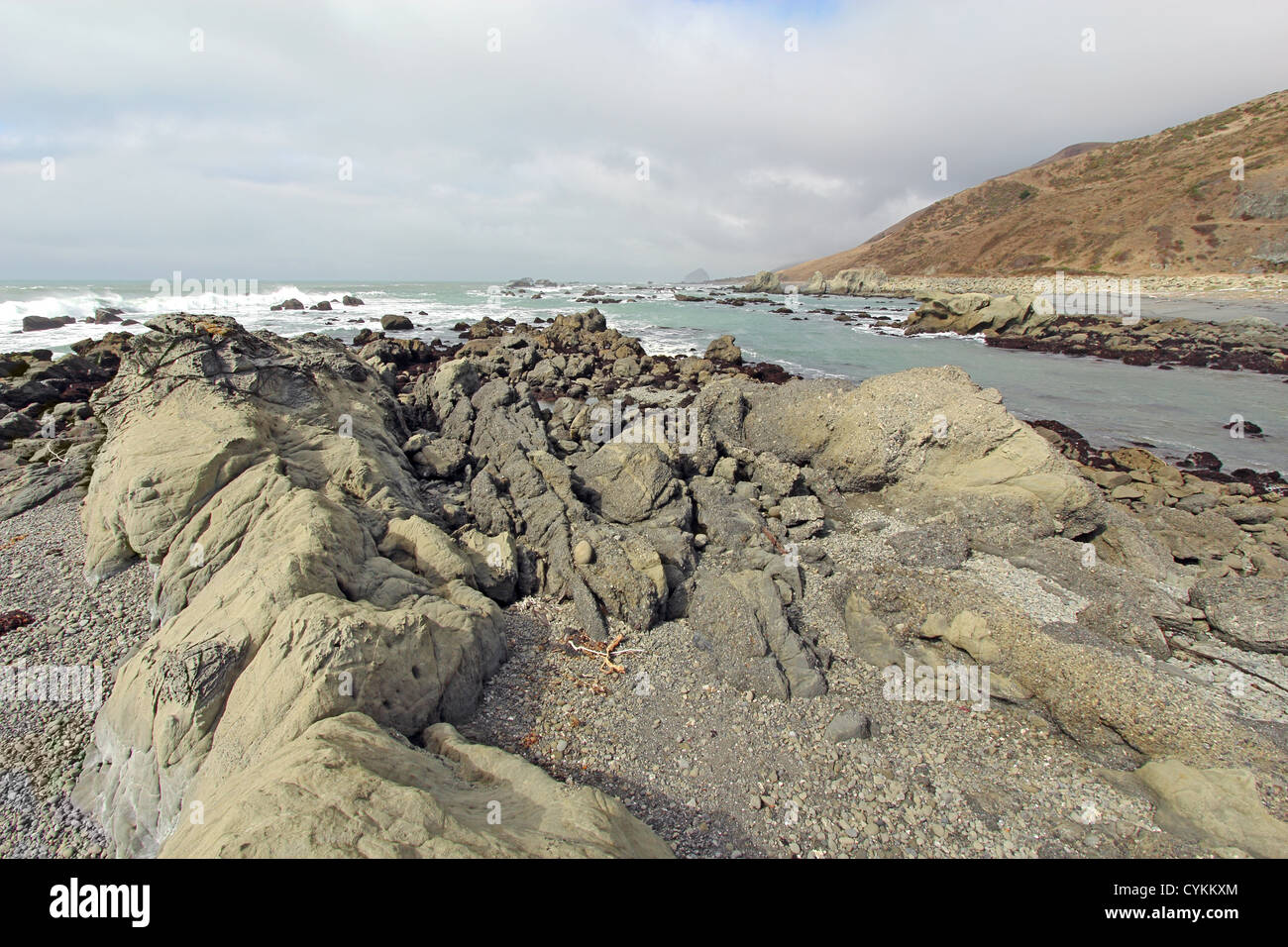 Ein felsiger Strand von Straße beginnt an der verloren Küste von Kalifornien mit dem brechen der Wellen und ein bewölkter Himmel Stockfoto