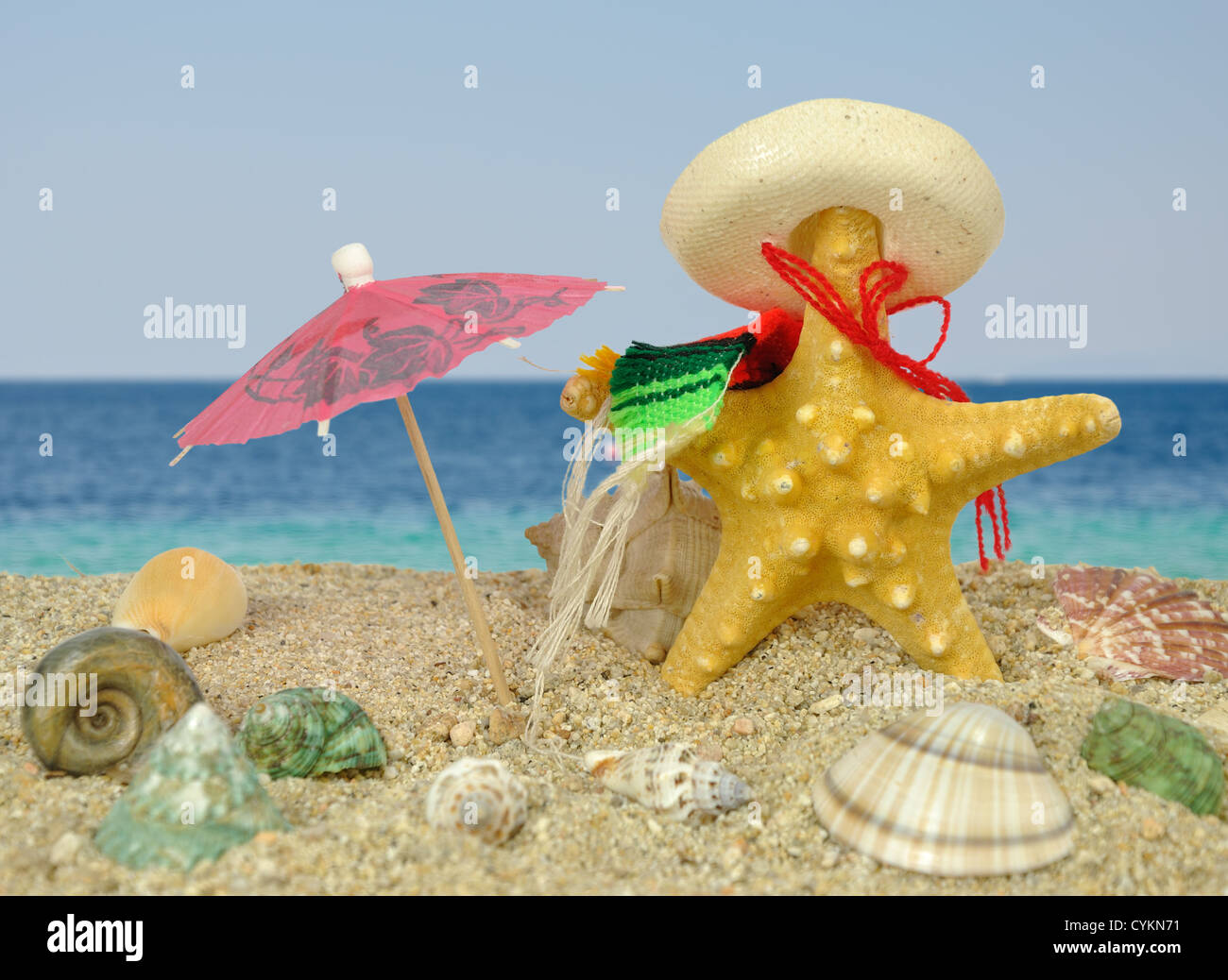 Sommer-Szene #17 - Seestern mit Sombrero und Sonnenschirm Stockfoto