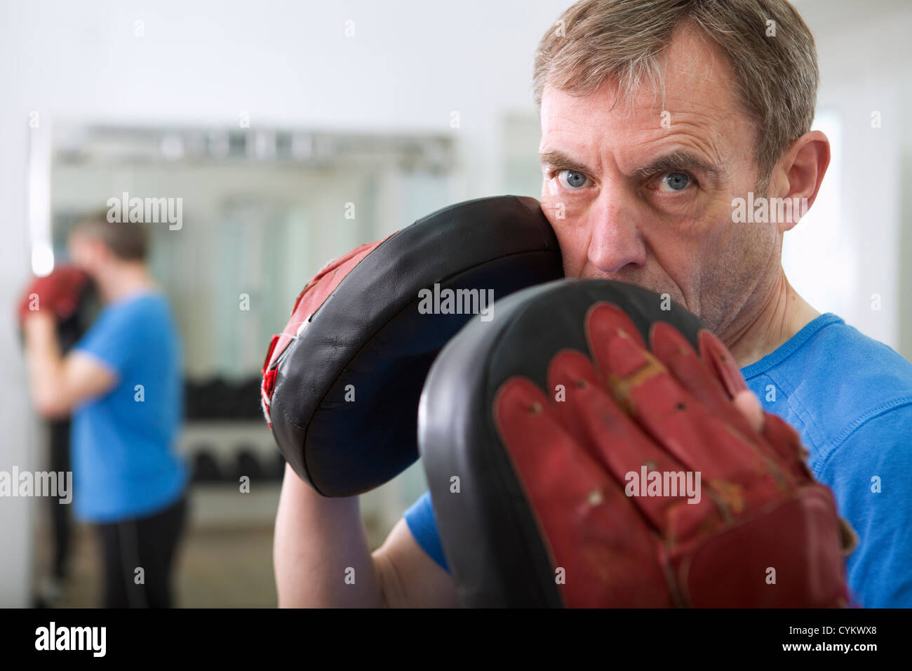 Trainer tragen gepolsterte Handschuhe im Fitness-Studio Stockfoto