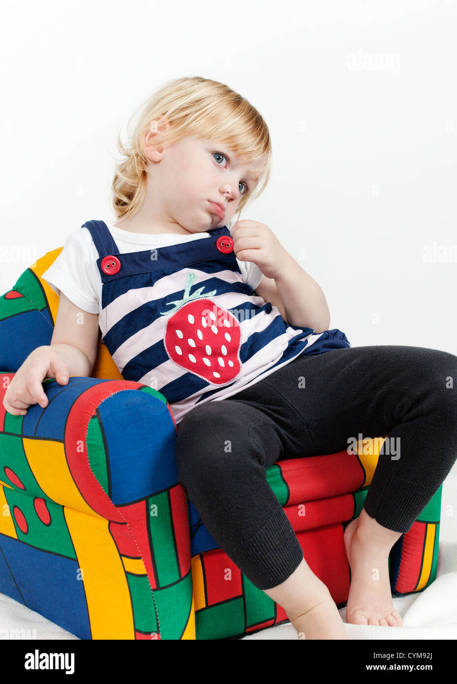 Kleines Mädchen in einem bunten Sessel Stockfoto