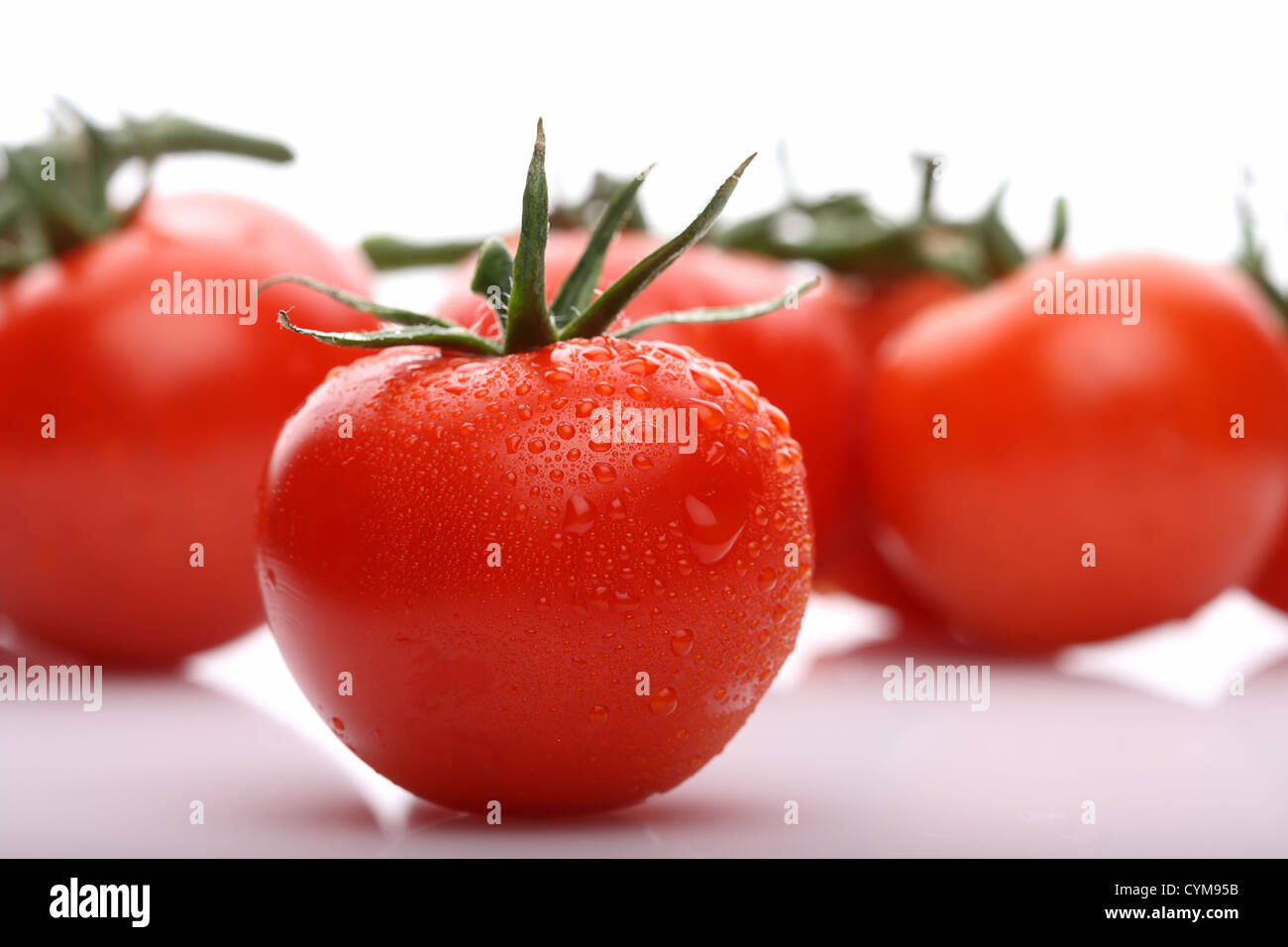 perfekte rote Tomate mit Tomaten auf Hintergrund, Licht Schatten vorne, soft-Fokus Stockfoto