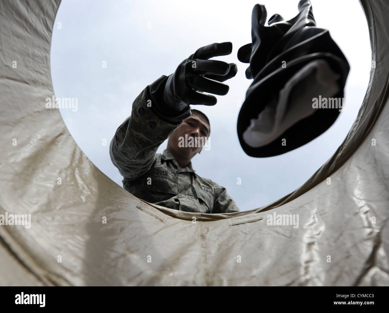 Airman 1st Class Wei-Sean Chan, ein 19. Equipment Maintenance Squadron Flugzeug Bauunterhaltung Geselle, sinkt seine chemische Handschuhe in einem Lagerplatz nach Durchlaufen einer simulierten de-Kontamination während die Fähigkeit zu überleben und Krieger zu betreiben Stockfoto