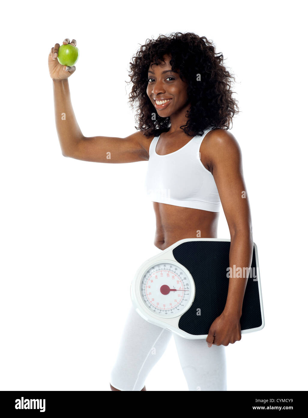 Athlet hält grünen Apfel und einem Gewicht von Maschine tragen weiße Sport-outfit Stockfoto