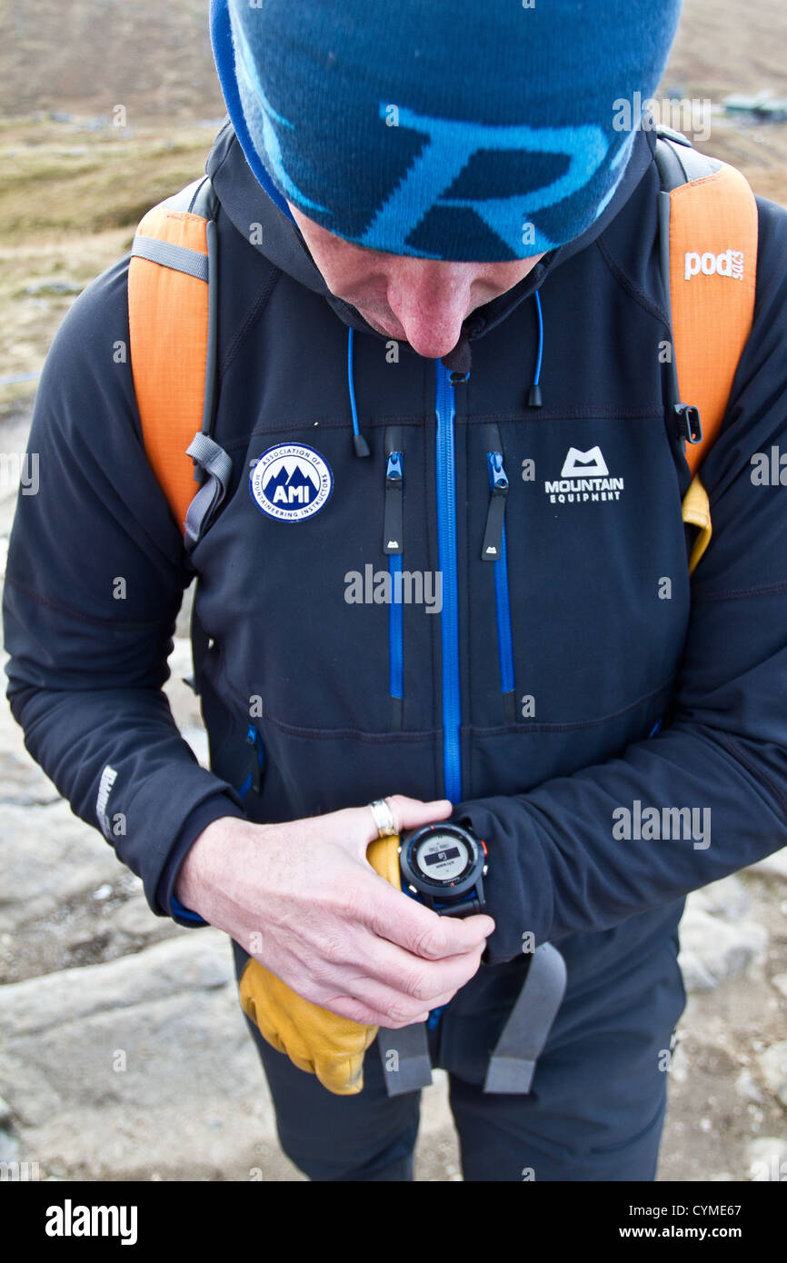 Ein Mann mit einer Armbanduhr GPS-Navigationssystem in den schottischen Bergen Stockfoto