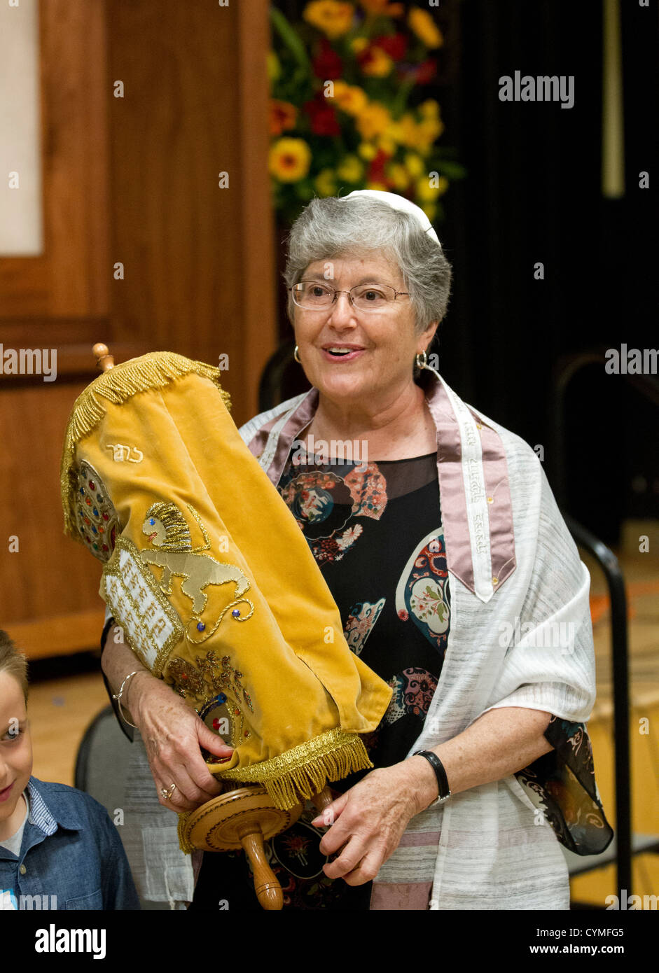 Jüdin, 67, hält Torah während ihre Bat-Mizwa-Feier während Sabbath Service in ihrer Synagoge Stockfoto