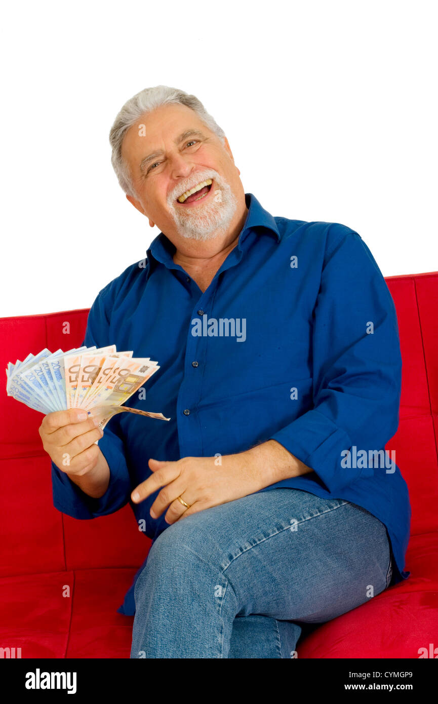 älterer Mann auf der Couch mit Geld in der hand Stockfoto