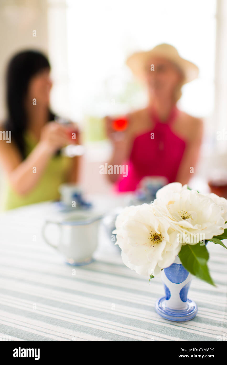 Die Frauen haben eine gute Zeit zusammen, den engen Fokus auf Vorderseite der Blumenvase Stockfoto