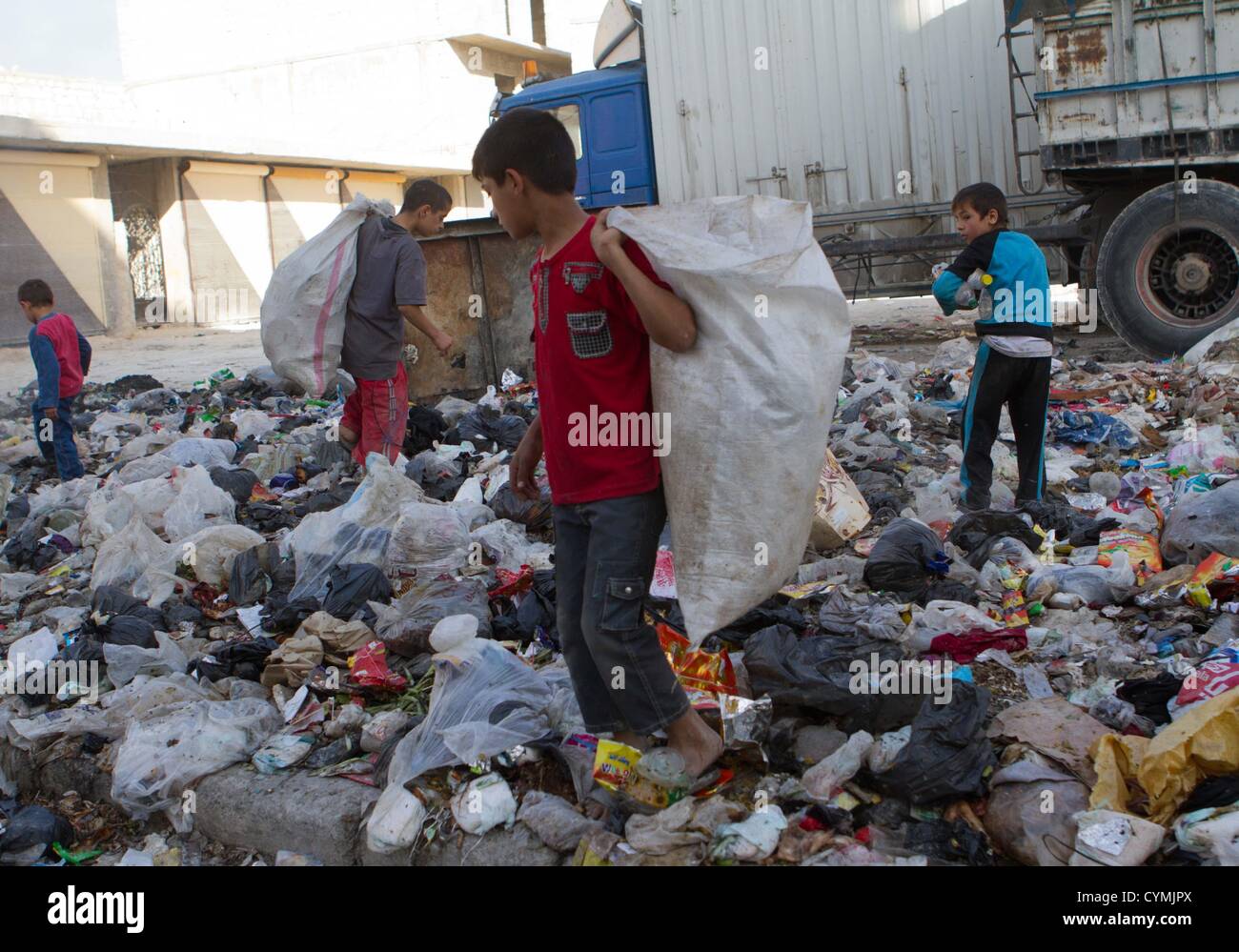 7. November 2012 - Aleppo, Syrien: Kinder aufräumen durch Papierkorb Shikh gesagt. Stockfoto