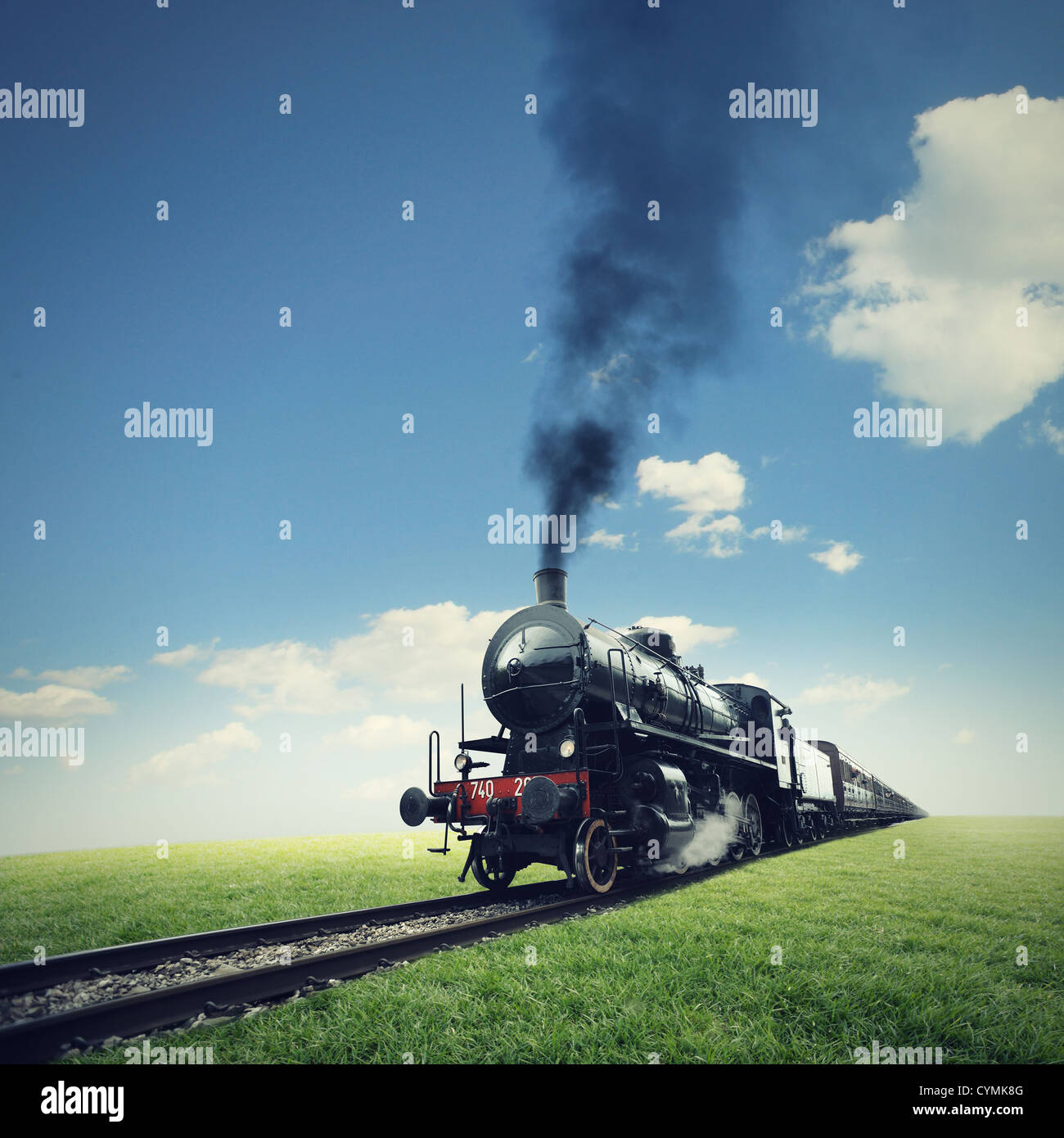 Dampfmaschine Bahn kreuzt einen grünen Rasen Stockfoto