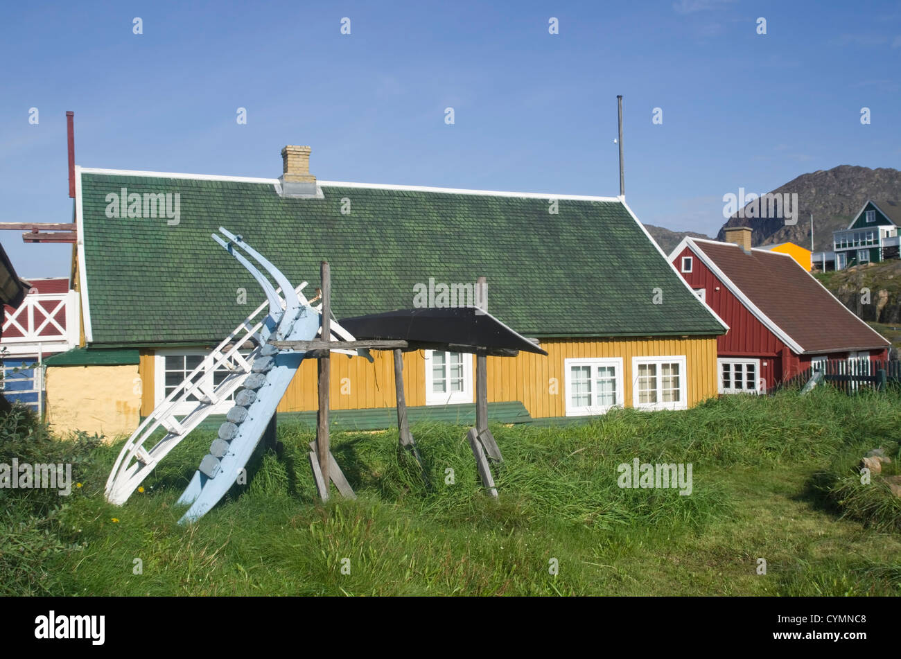 Immobilien in Sisimiut, SW-Grönland mit Schlitten vorne in leuchtenden Farben Stockfoto