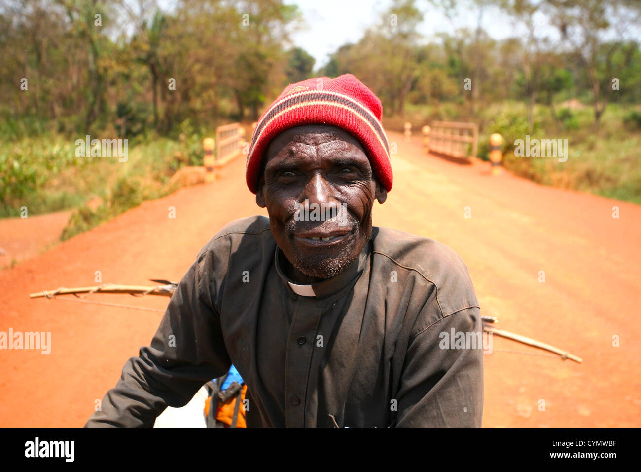 Nicht identifizierte Priester mit Bogen & Pfeil auf Rückseite Fahrrad in der Nähe von Yambio, Western Equatoria, Süd-Sudan Ende 2010 Stockfoto