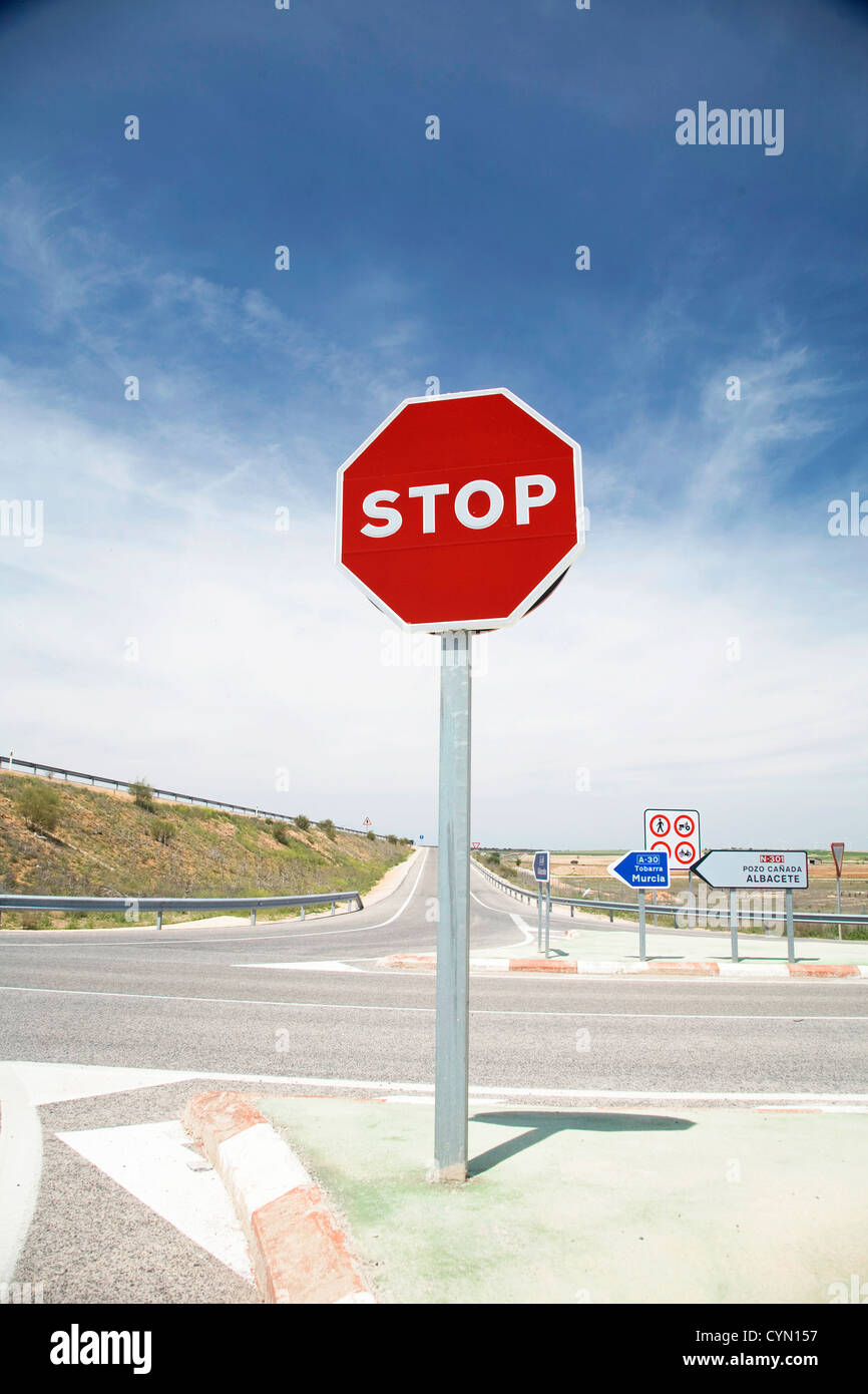 Stop-Schild neben einem Kreuz auf der spanischen Autobahn Stockfoto