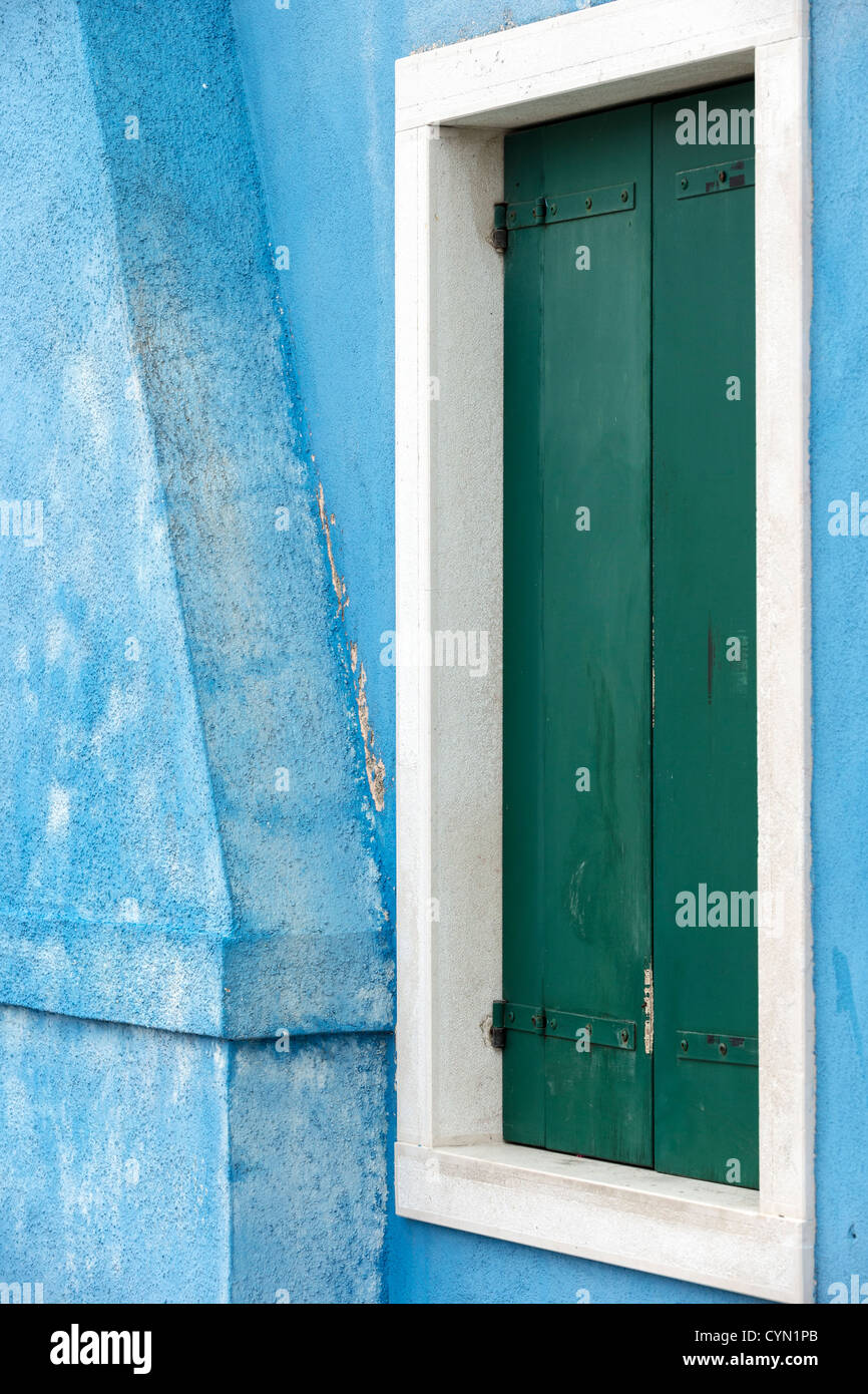 Detail eines Hauses gemalt Himmelblau, ein weißes Fenster mit grünen Fensterläden in Burano, Italien Stockfoto