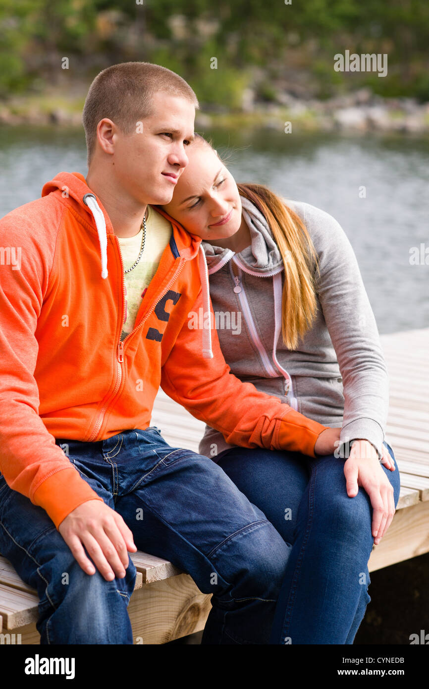 Junge Liebhaber sitzen auf dem Dock zusammen, vertikalen format Stockfoto