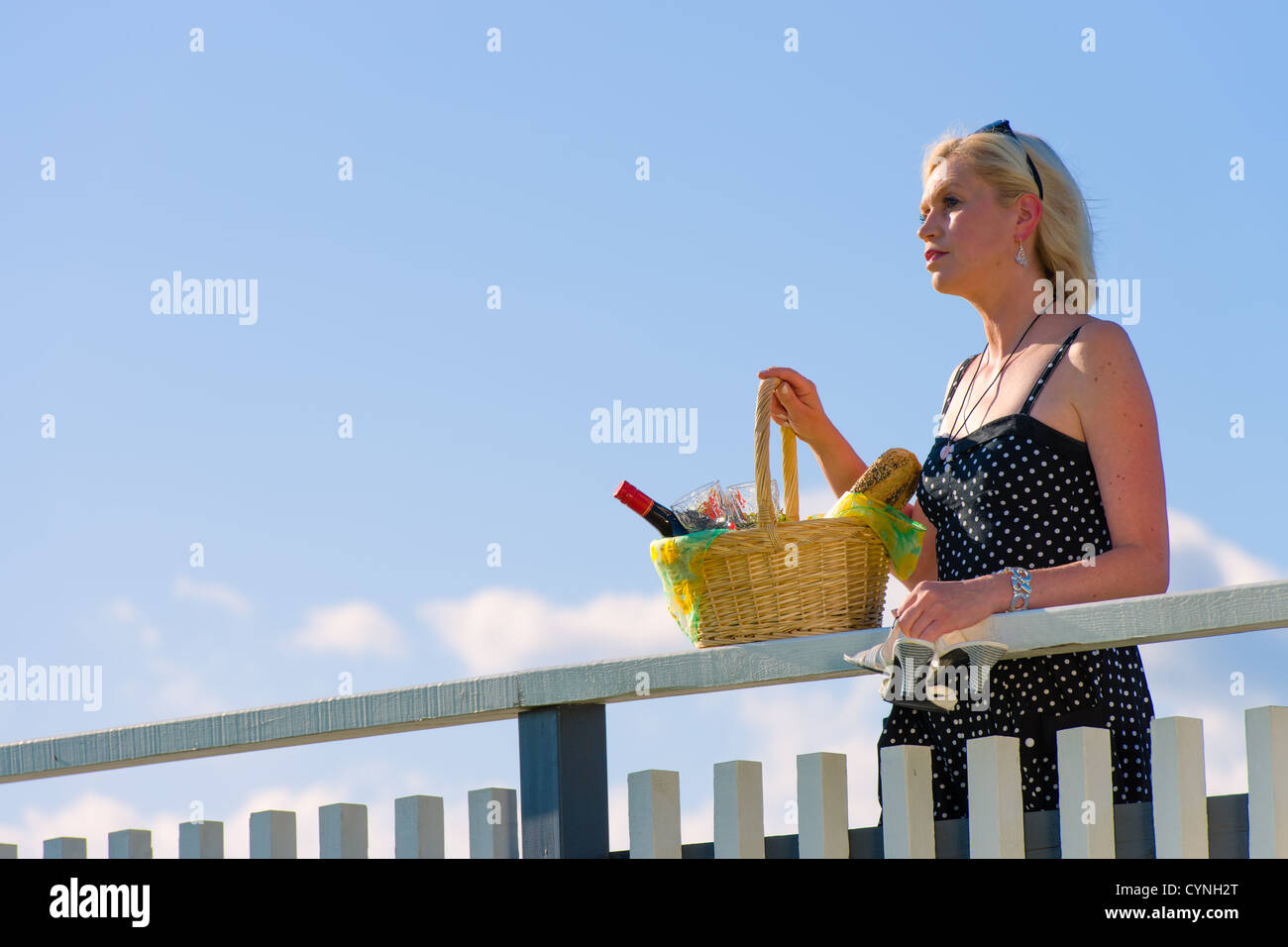 Frau an einen Zaun gelehnt und wartet jemand Stockfoto