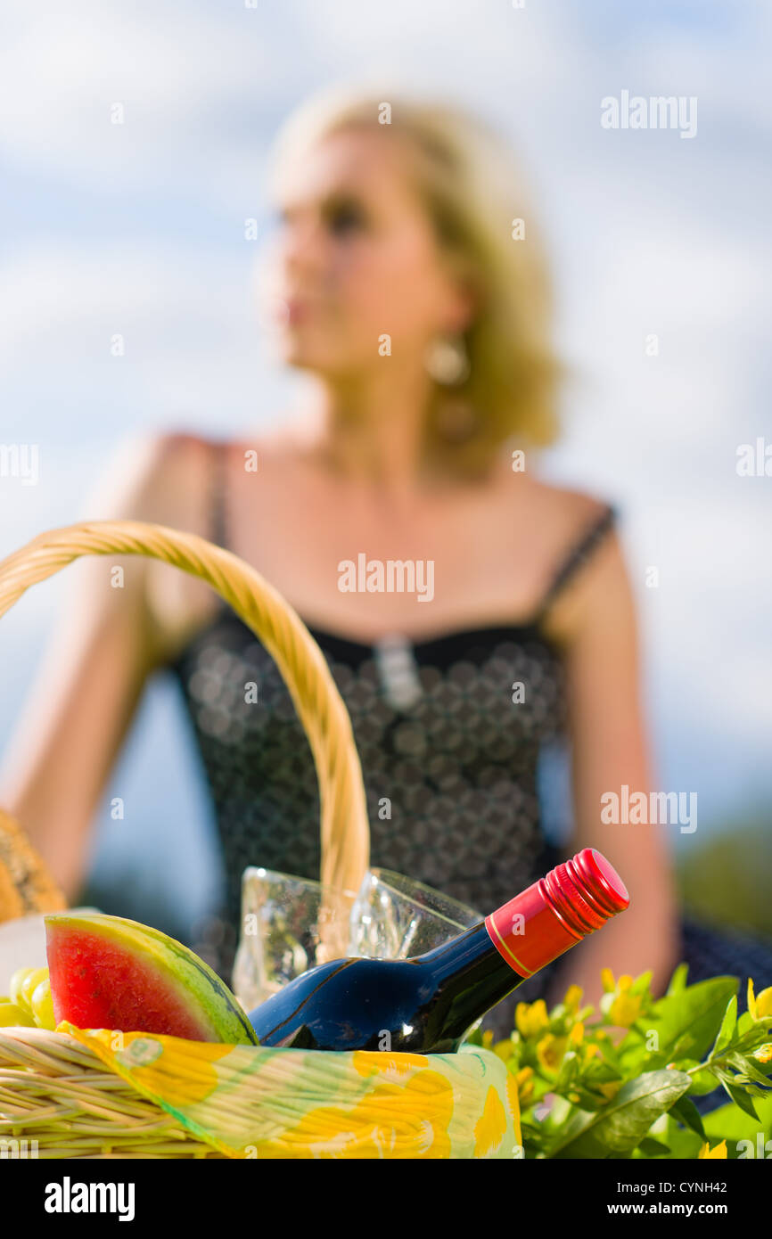 Picknick-Korb und Frau aus dem Blickfeld auf Hintergrund, Hochformat Stockfoto