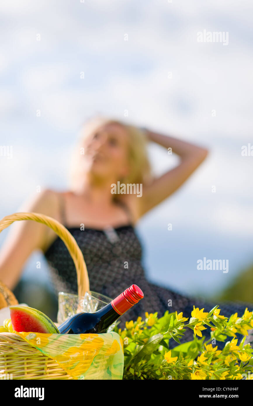 Picknick-Korb und lächelnde Frau aus dem Blickfeld auf Hintergrund, Hochformat Stockfoto