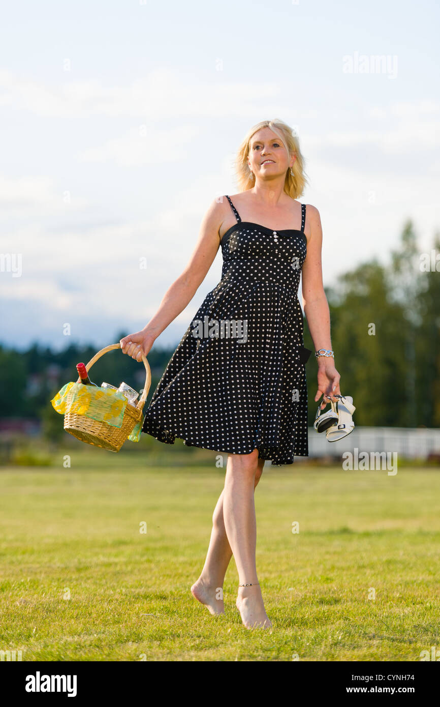 Froh, dass Frau zum Picknick, barfuß, geht sieht sie weit Stockfoto