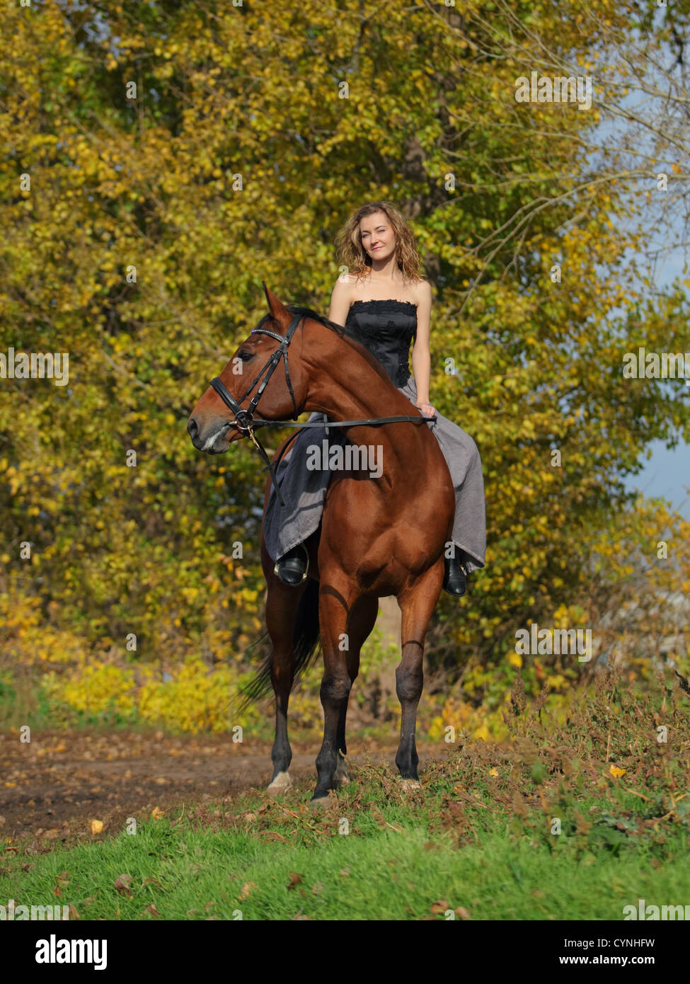 Cowgirl in Vintage-Kleid auf einem Pferd sitzend Stockfoto