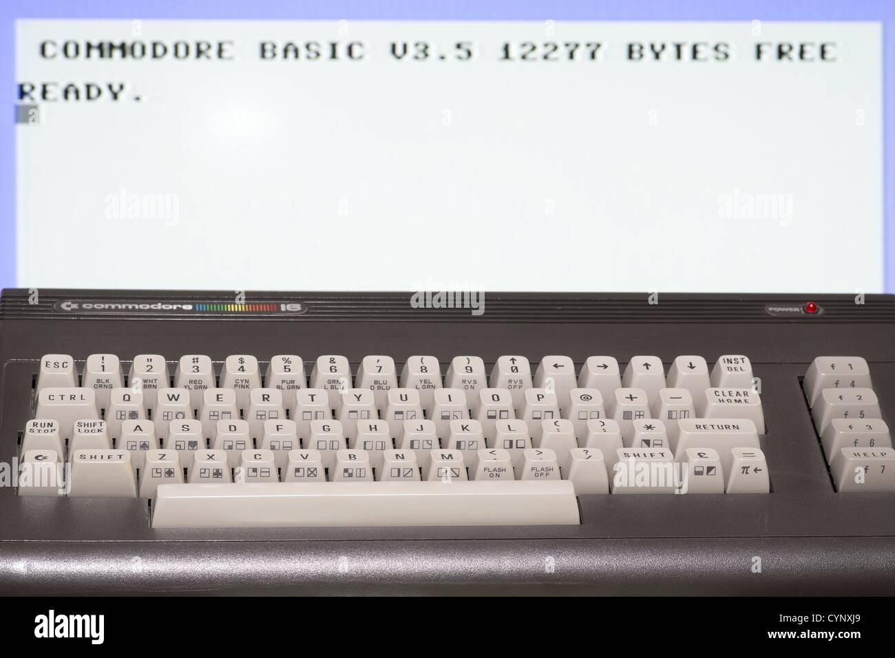 Commodore 16 Heimcomputer mit ersten Bildschirm im Hintergrund Stockfoto